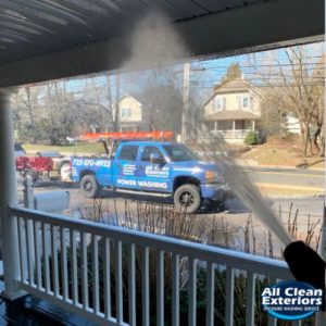 close up power washing the roof of a porch in Monmouth County, NJ